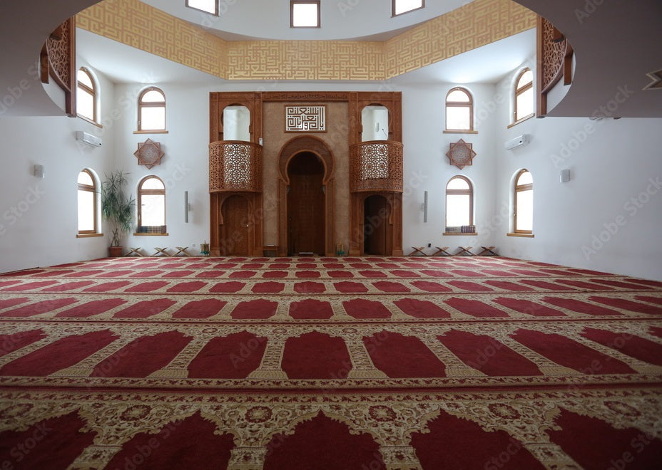 Red patterned carpet in a spacious mosque prayer hall with arched windows, Bhadohi Carpets House