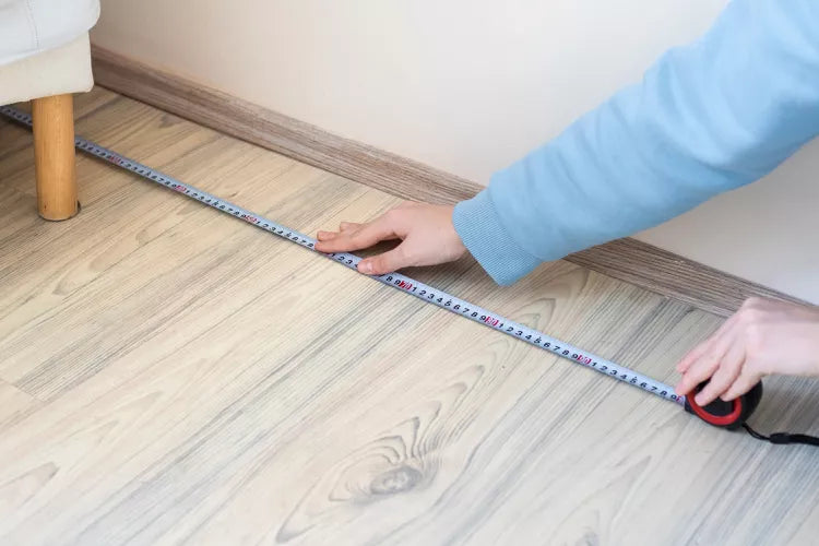 Person measuring floor with tape for carpet sizing, Bhadohi Carpets House, modern home