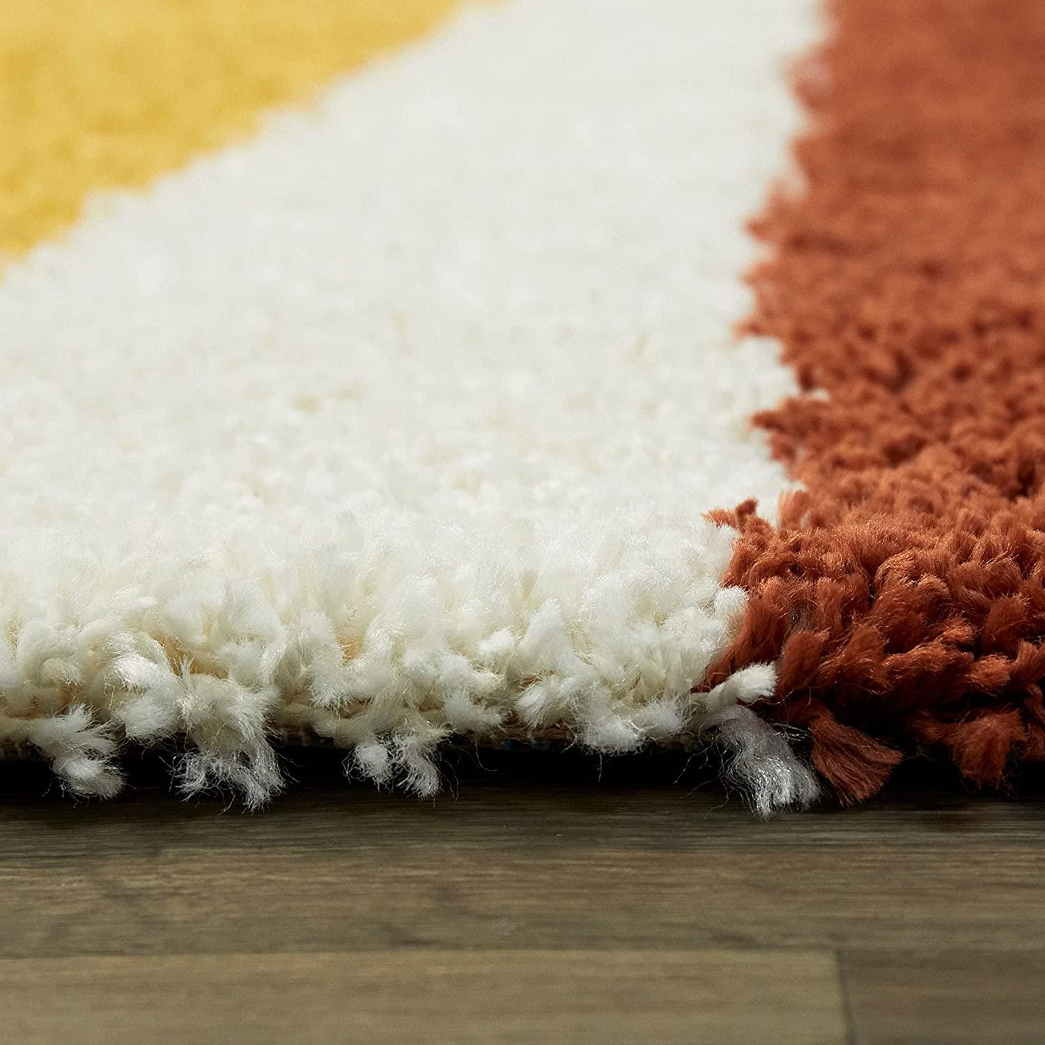 Close-up of a Bhadohi Carpets House shaggy rug with white, brown, and yellow stripes on wooden floor