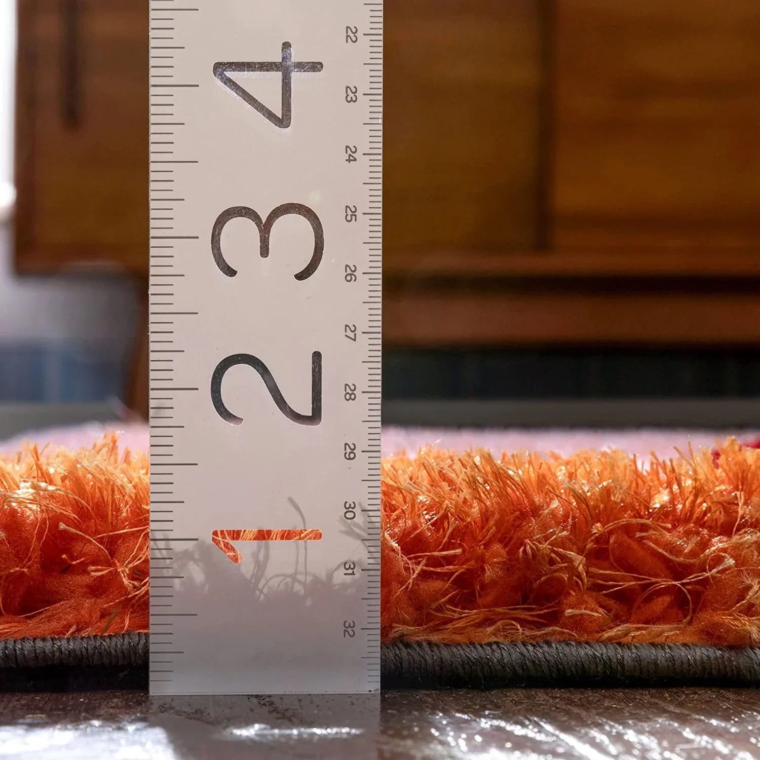 Close-up of orange shaggy carpet rug with measuring scale for thickness, Bhadohi Carpets House