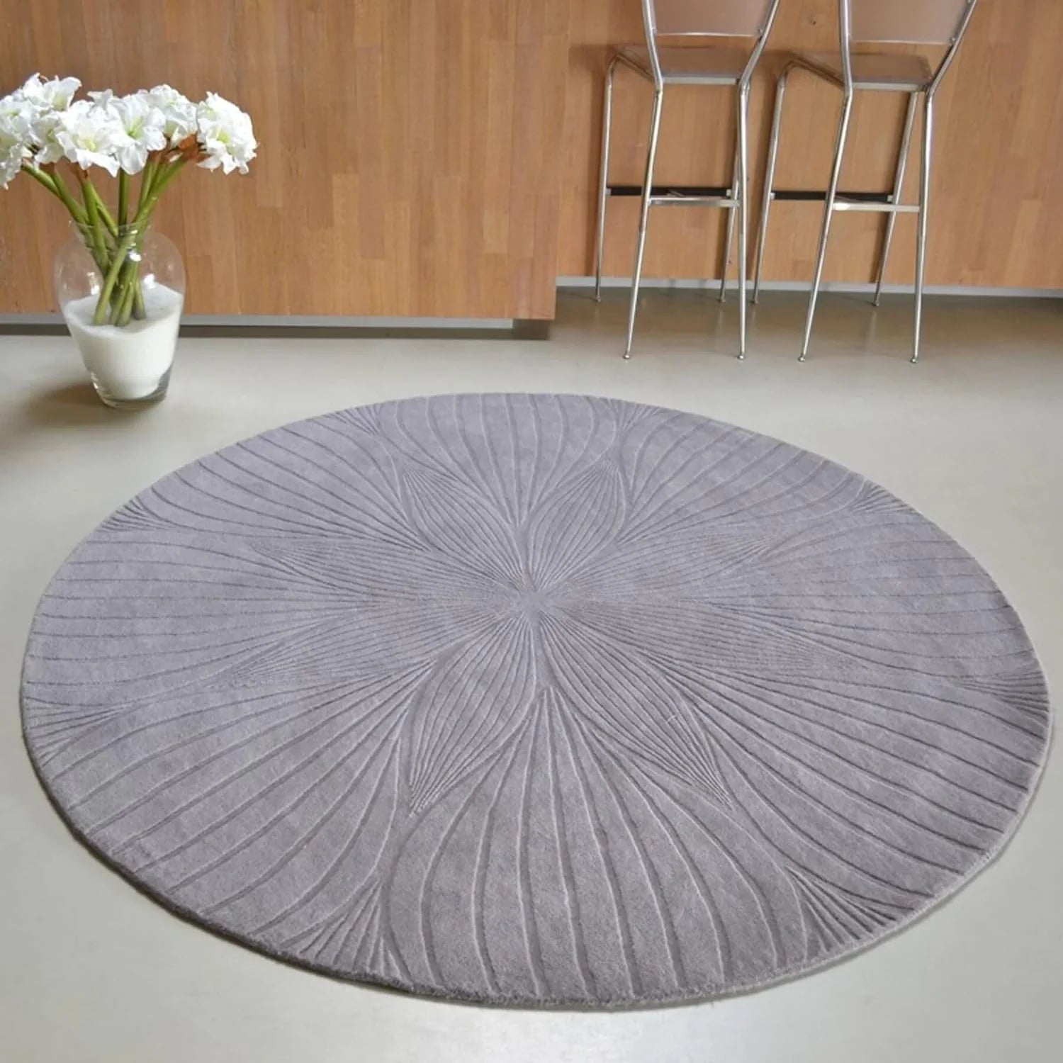 Round grey wool carpet with subtle floral pattern in modern home, Bhadohi Carpets House