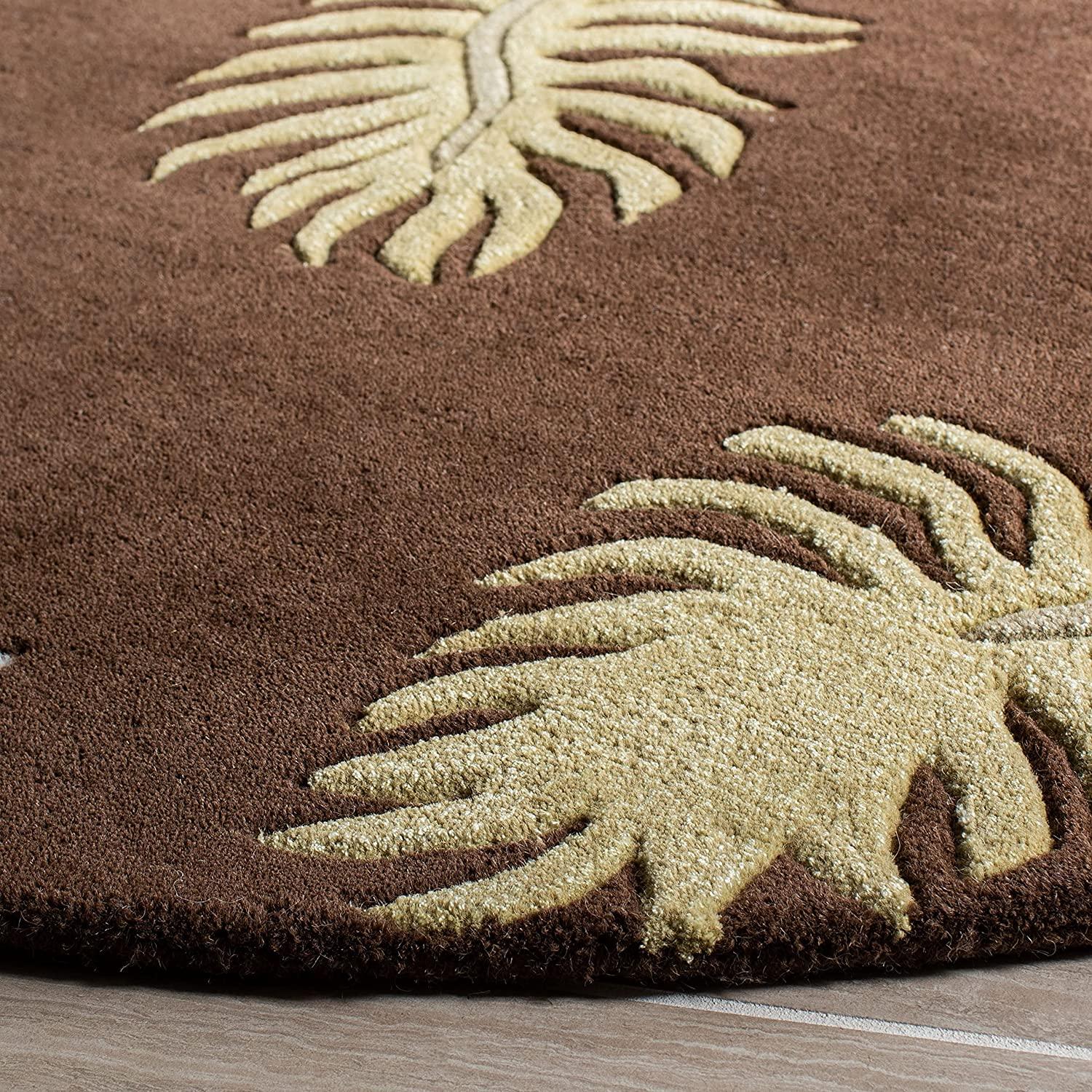 Brown round wool carpet with beige leaf pattern from Bhadohi Carpets House on wooden floor