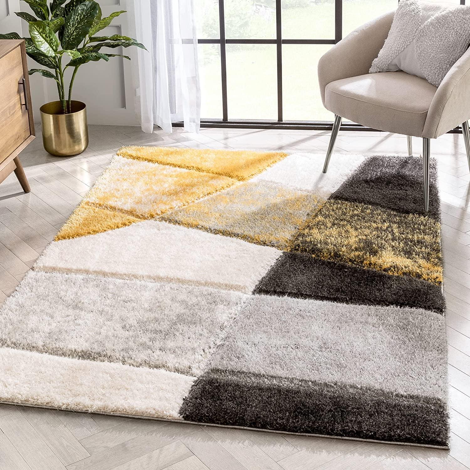 Modern shaggy carpet rug with yellow, grey, and white geometric pattern in a bright living room
