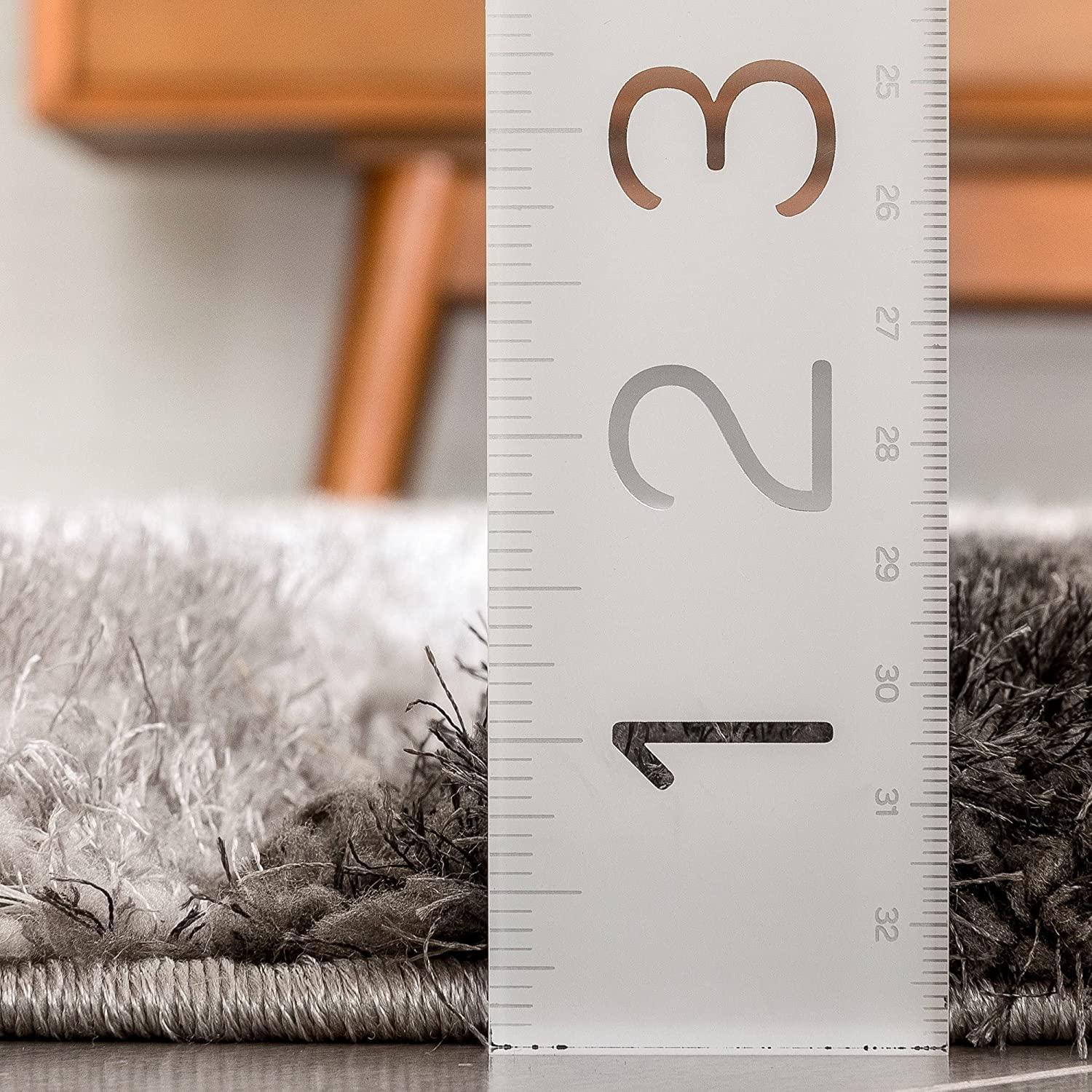 Close-up of shaggy grey carpet rug pile with ruler measuring thickness, Bhadohi Carpets House