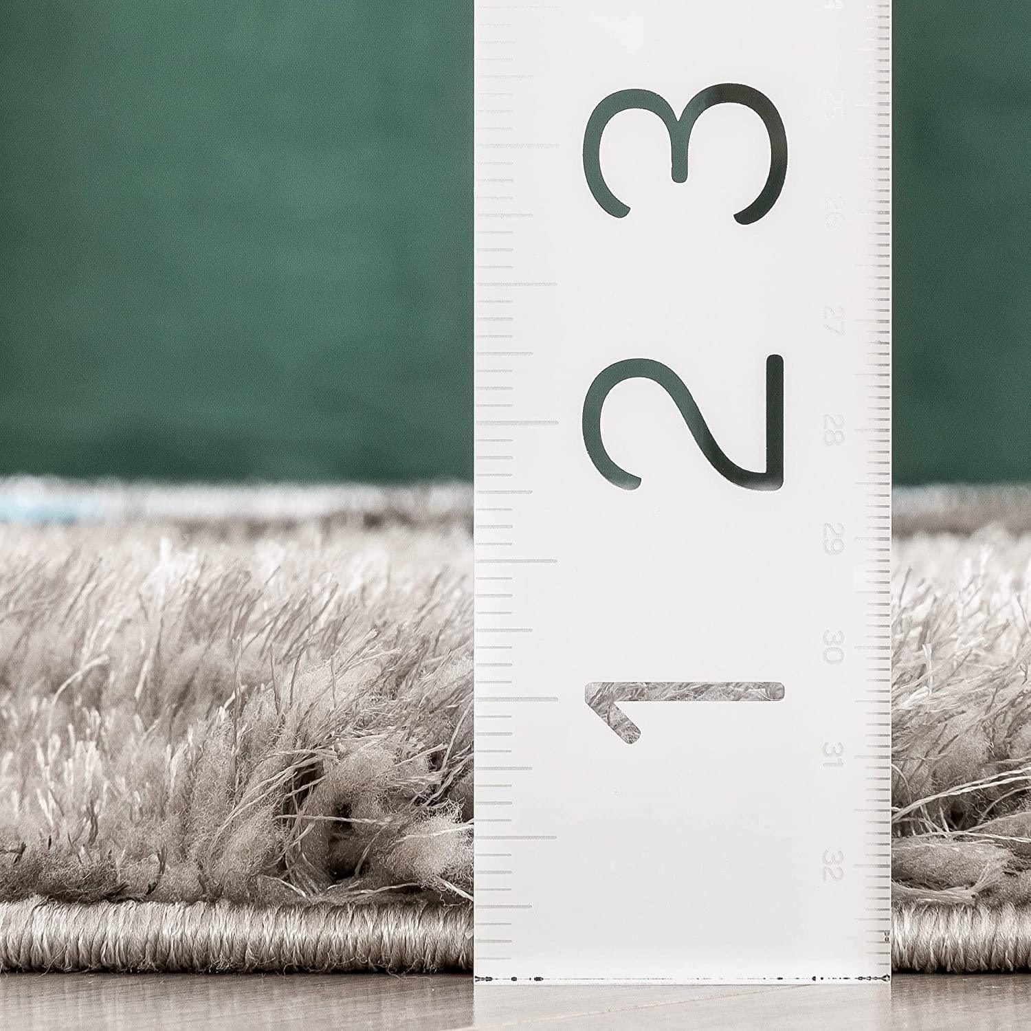 Close-up of a grey shaggy carpet from Bhadohi Carpets House with ruler showing pile height