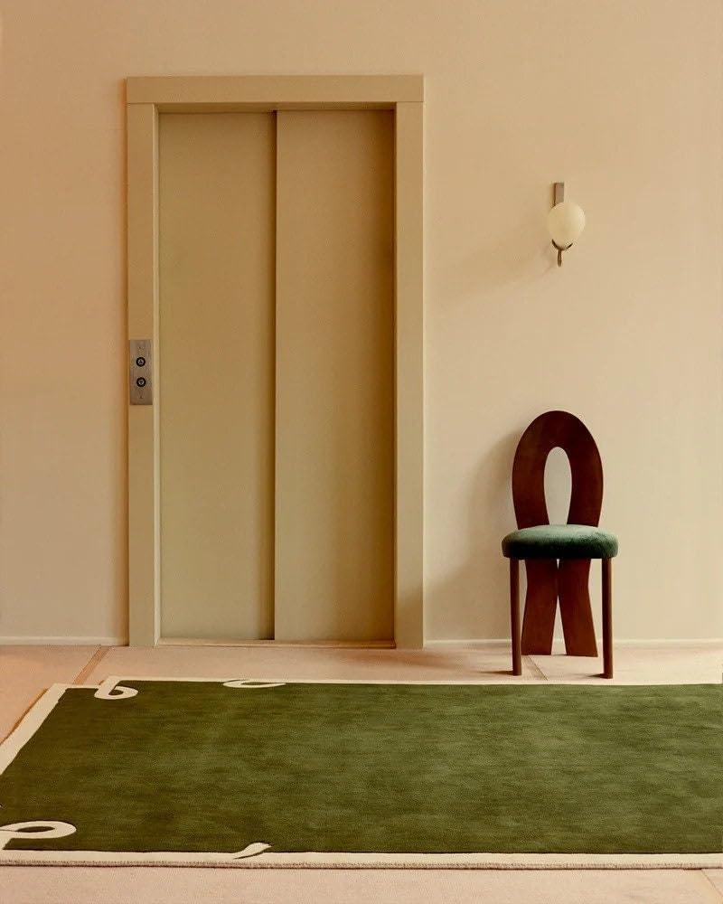 Modern olive green irregular carpet rug in stylish room with unique chair, Bhadohi Carpets House