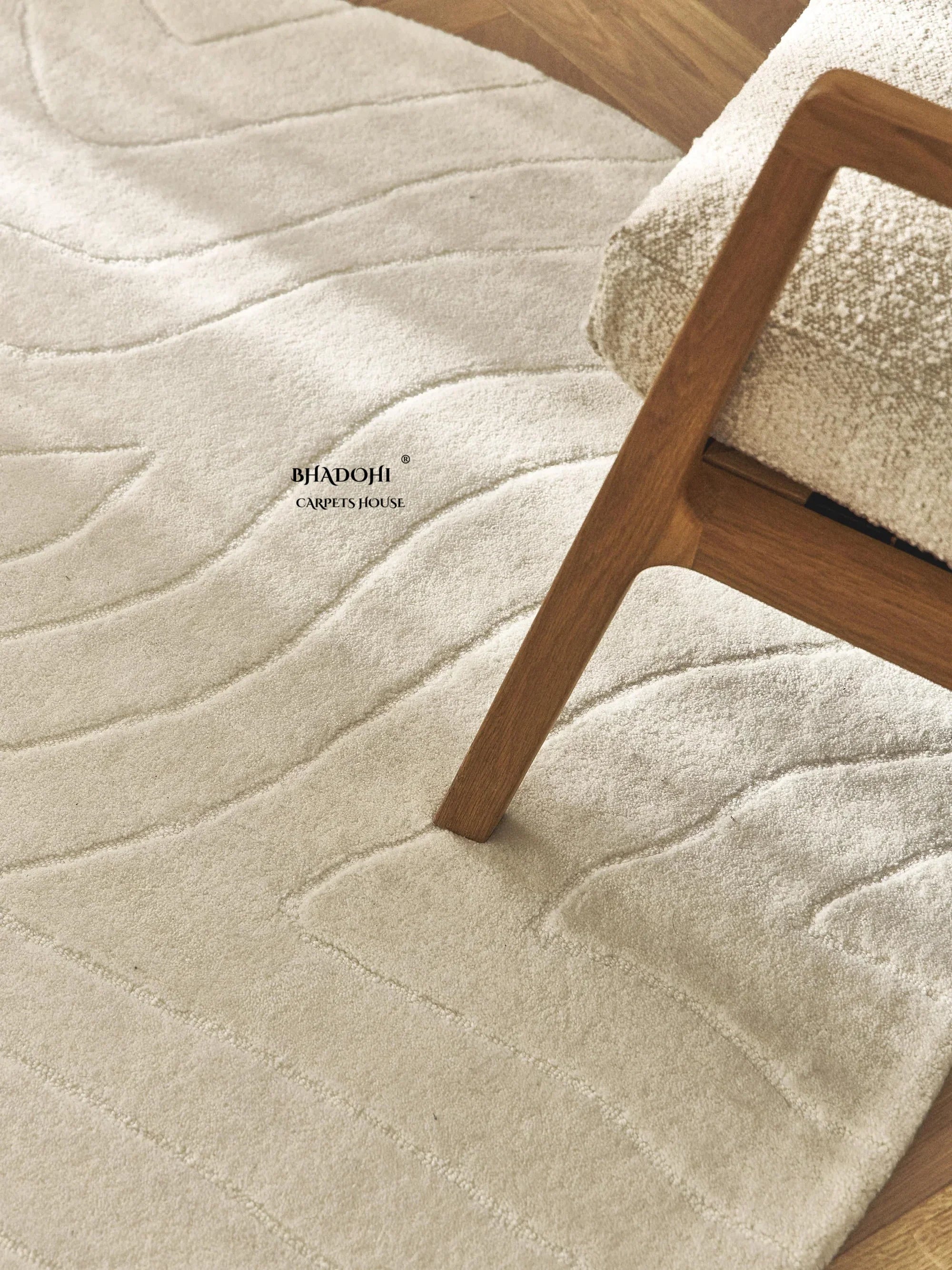 Modern cream wool rug with embossed pattern under a wooden chair, Bhadohi Carpets House
