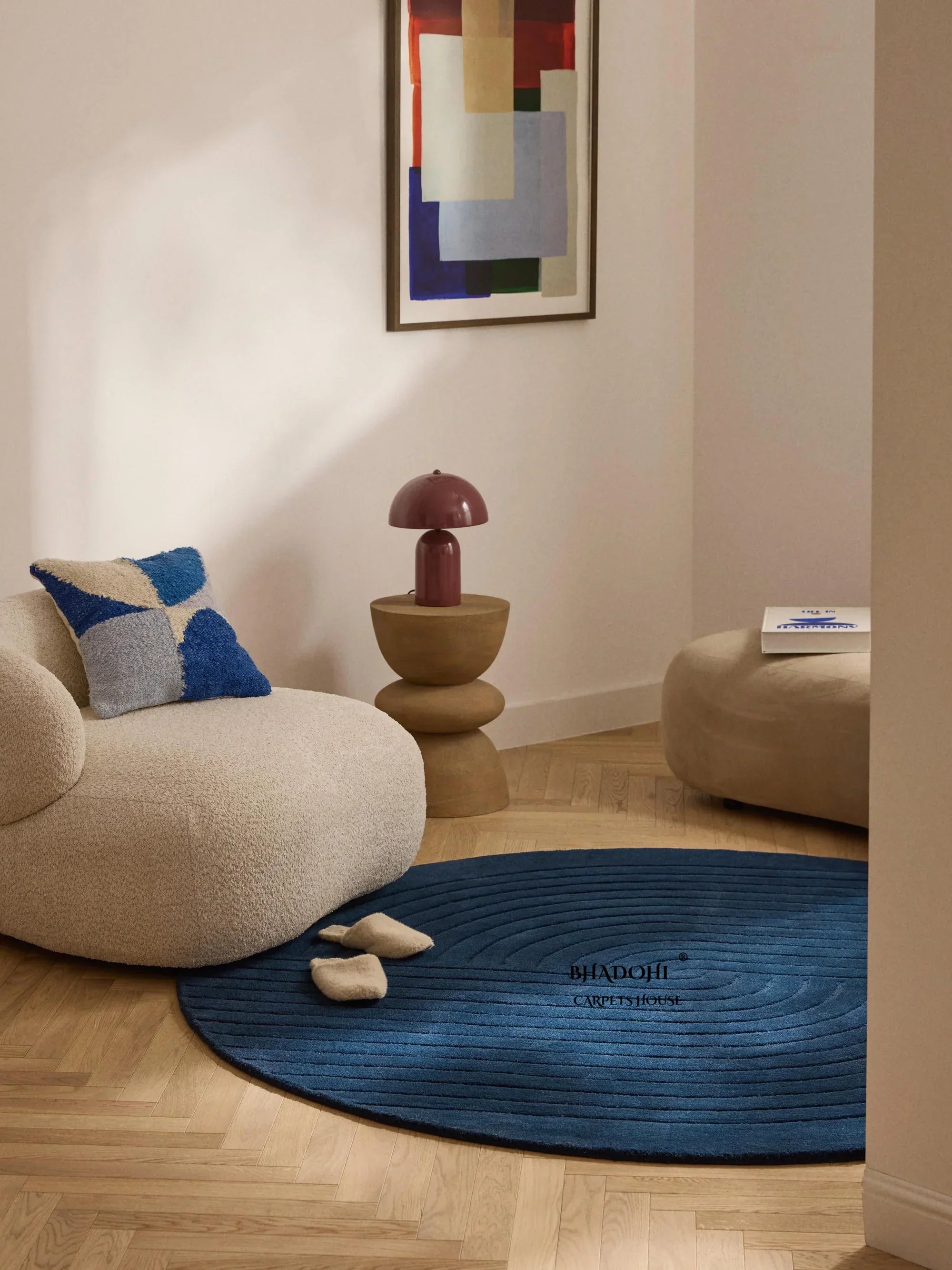 Modern living room with a blue round wool Bhadohi Carpets House rug on wooden floor