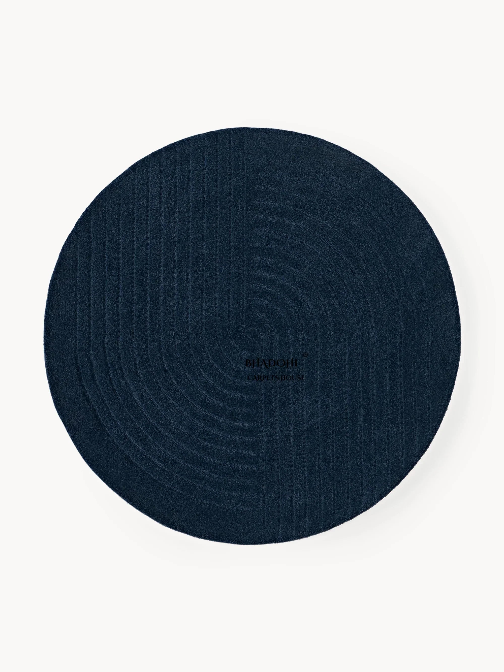 Round dark blue wool carpet rug with textured geometric pattern from Bhadohi Carpets House