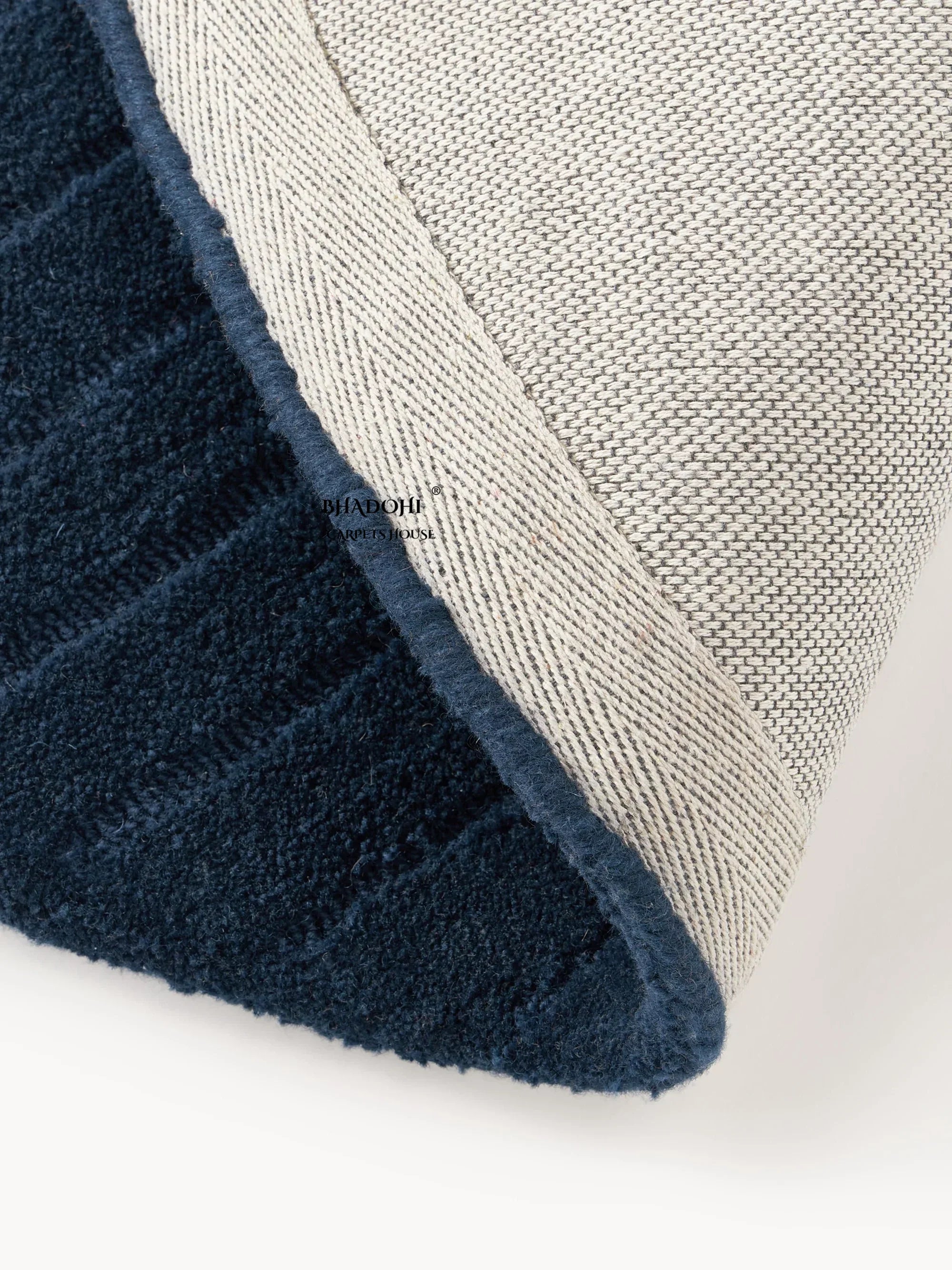 Close-up of navy blue round wool carpet rug with textured backing, Bhadohi Carpets House