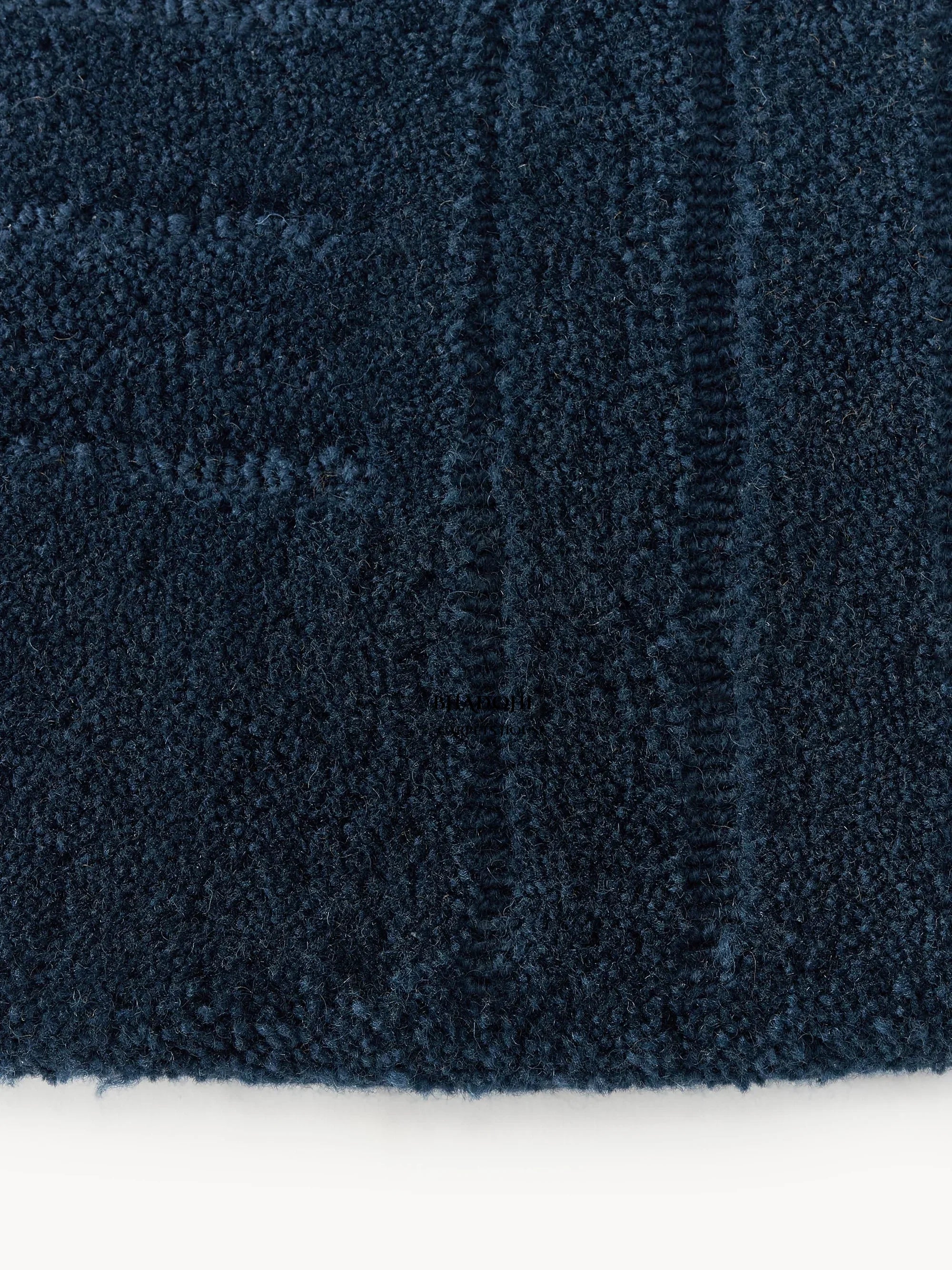 Close-up of dark blue wool carpet rug texture from Bhadohi Carpets House