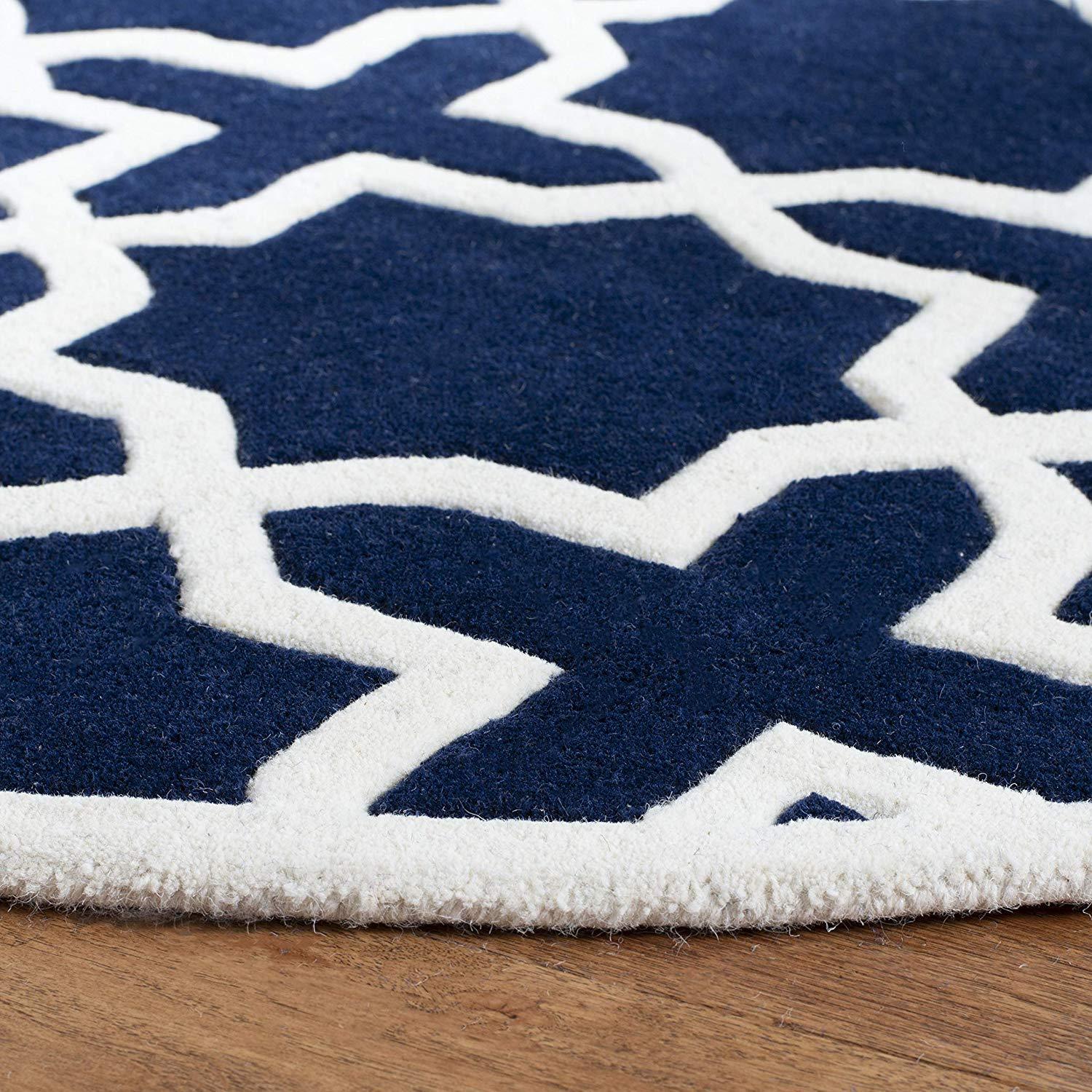 Round wool carpet rug with blue and white geometric pattern on wooden floor, Bhadohi Carpets House