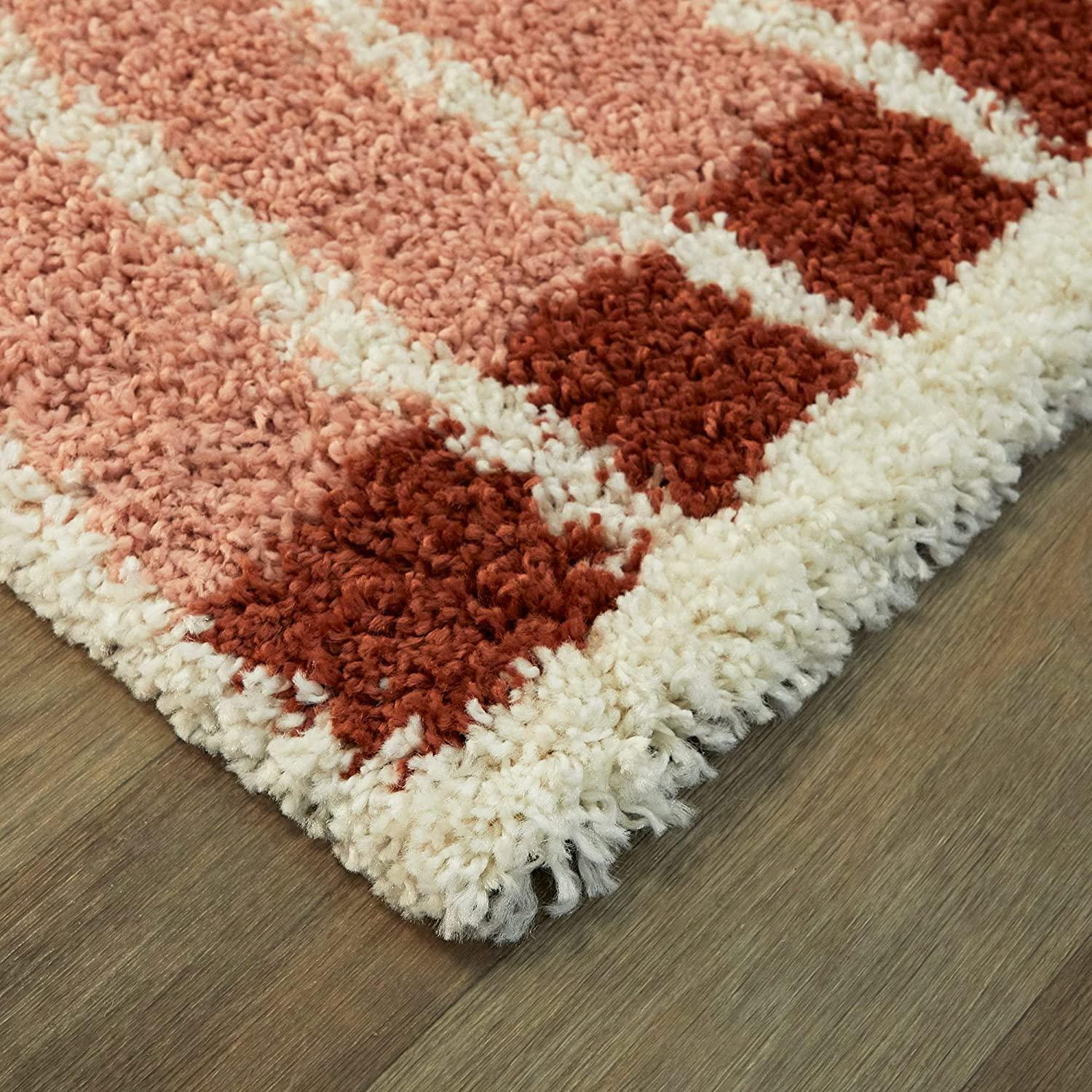 Shaggy carpet rug with red, pink, and white stripes on wooden floor, Bhadohi Carpets House