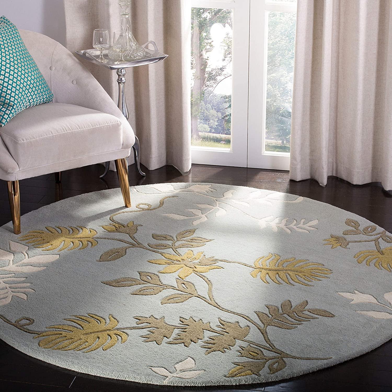 Light grey round wool carpet with leaf motifs in a modern living room, Bhadohi Carpets House