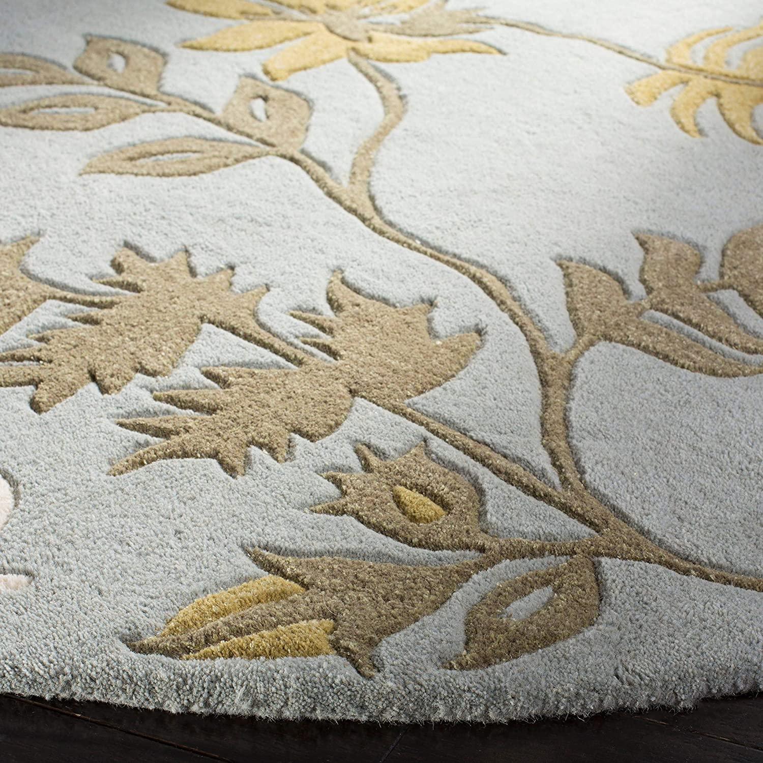 Light grey round wool carpet with beige floral leaf pattern from Bhadohi Carpets House
