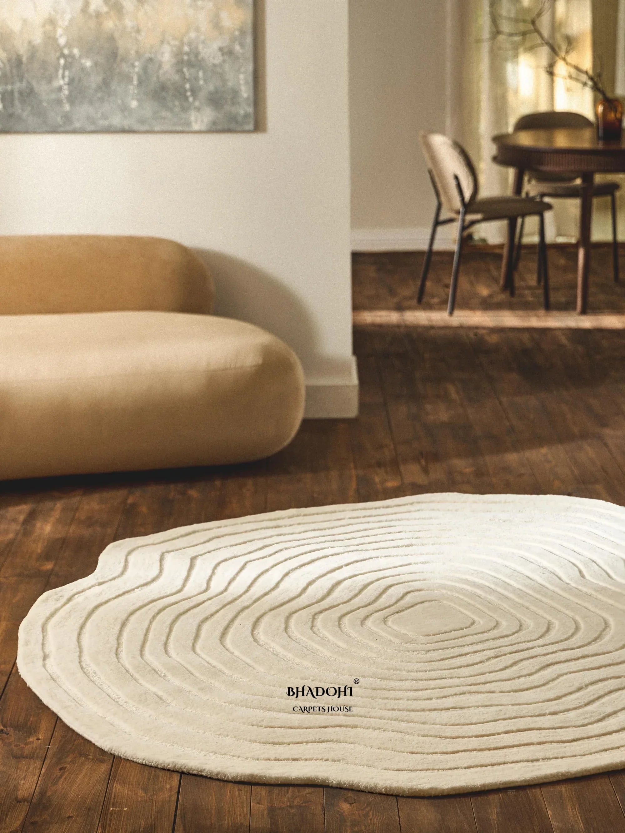 Modern living room with a round, textured white wool rug from Bhadohi Carpets House on wooden floor