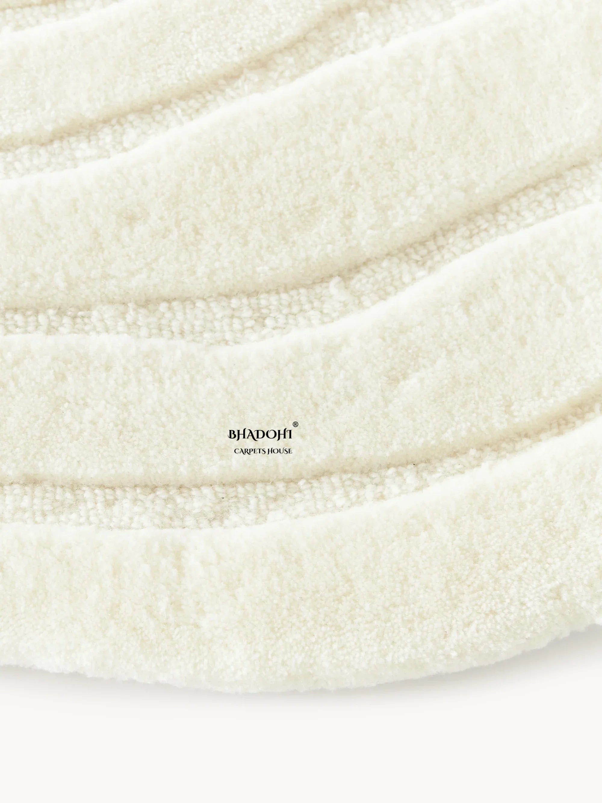 Close-up of cream round wool carpet rug with textured waves from Bhadohi Carpets House