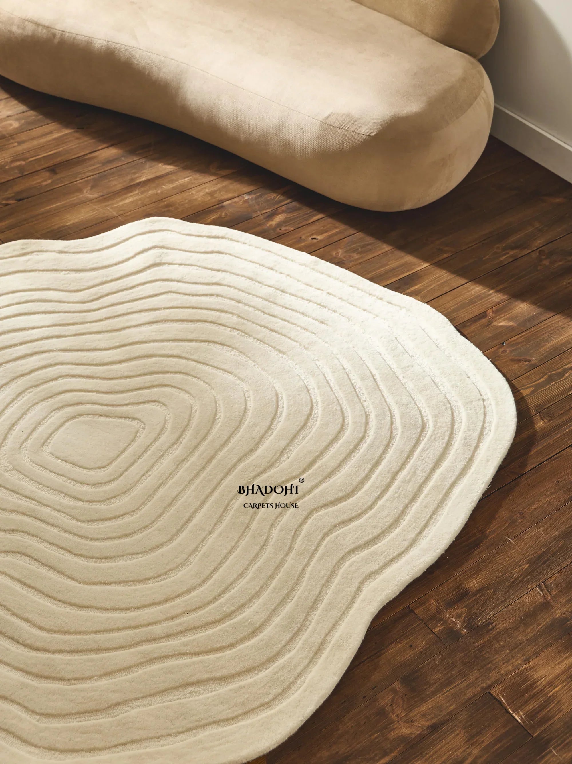Modern beige round wool carpet rug by Bhadohi Carpets House on wooden floor, India