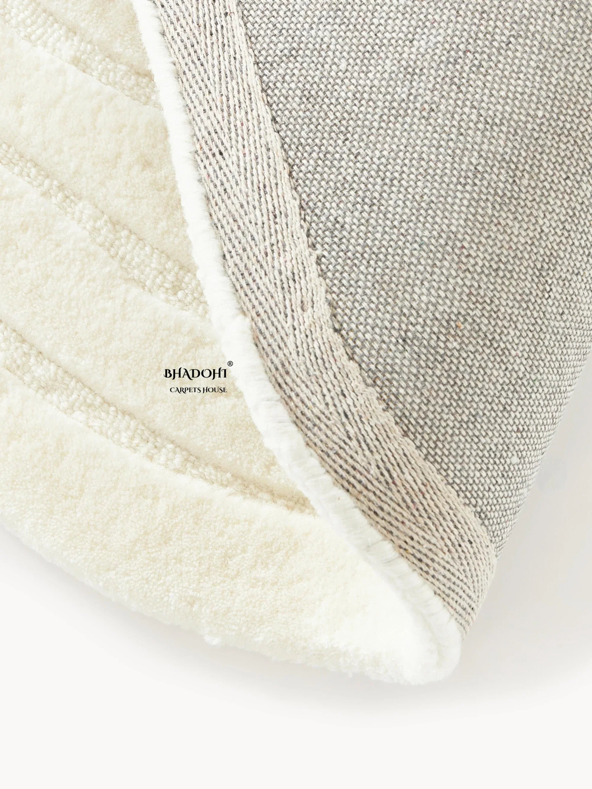 Close-up of Bhadohi Carpets House round wool rug showing soft cream pile and woven backing