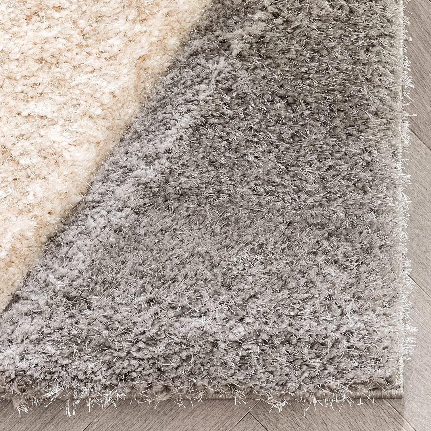 Close-up of a modern shaggy grey and cream carpet rug on a wooden floor from Bhadohi Carpets House