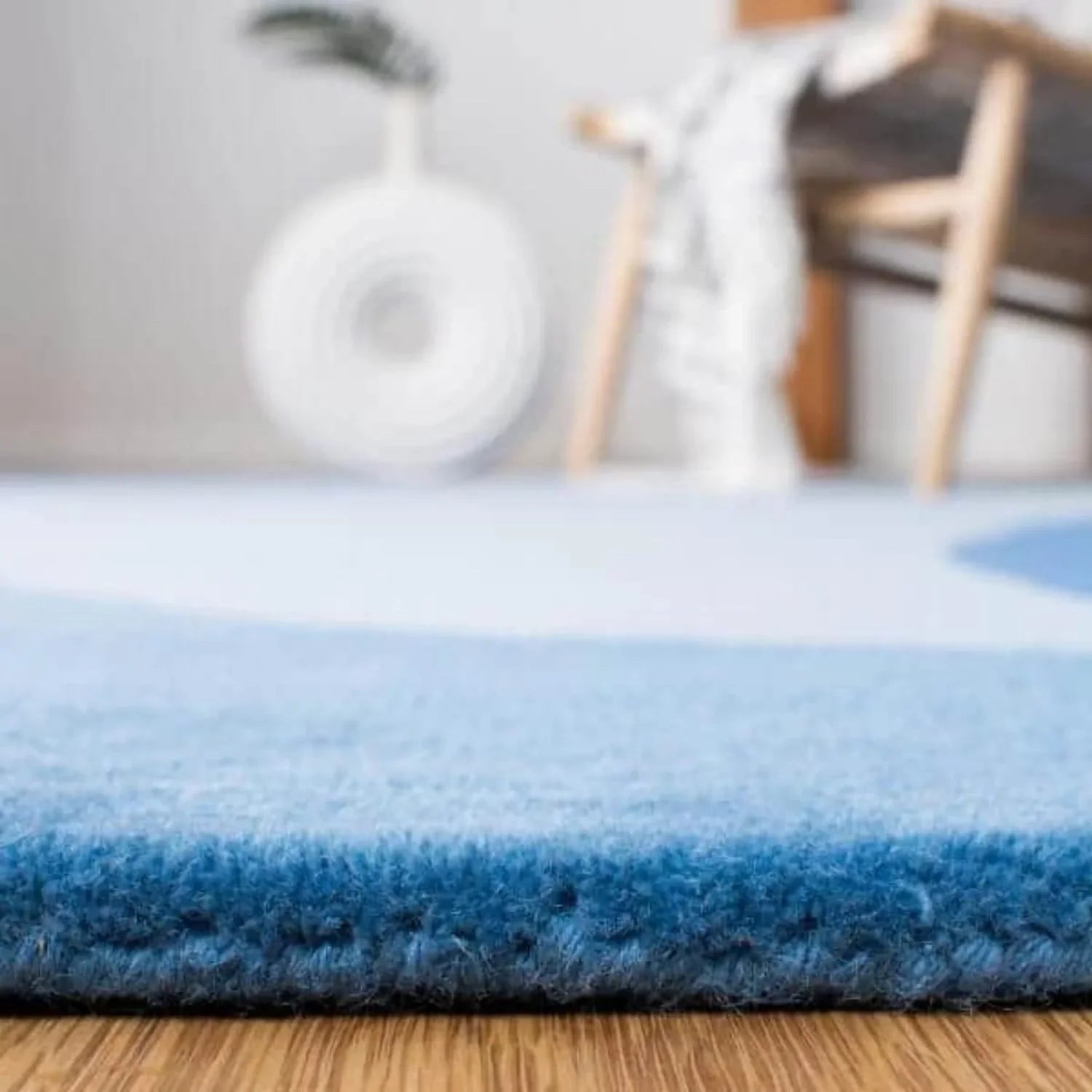 Close-up of blue round wool carpet rug on wooden floor, modern decor from Bhadohi Carpets House