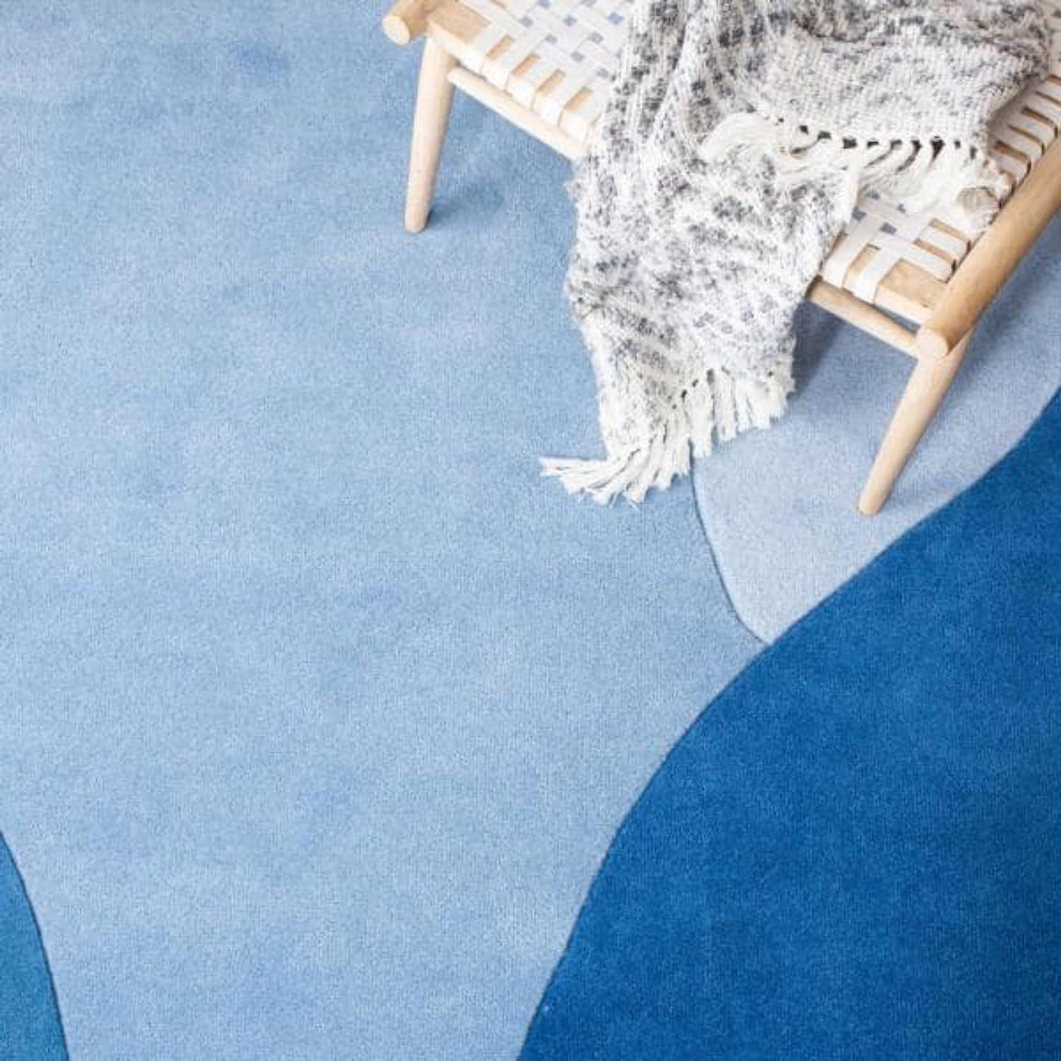 Modern blue wool round carpet rug with abstract design, bench and throw, Bhadohi Carpets House