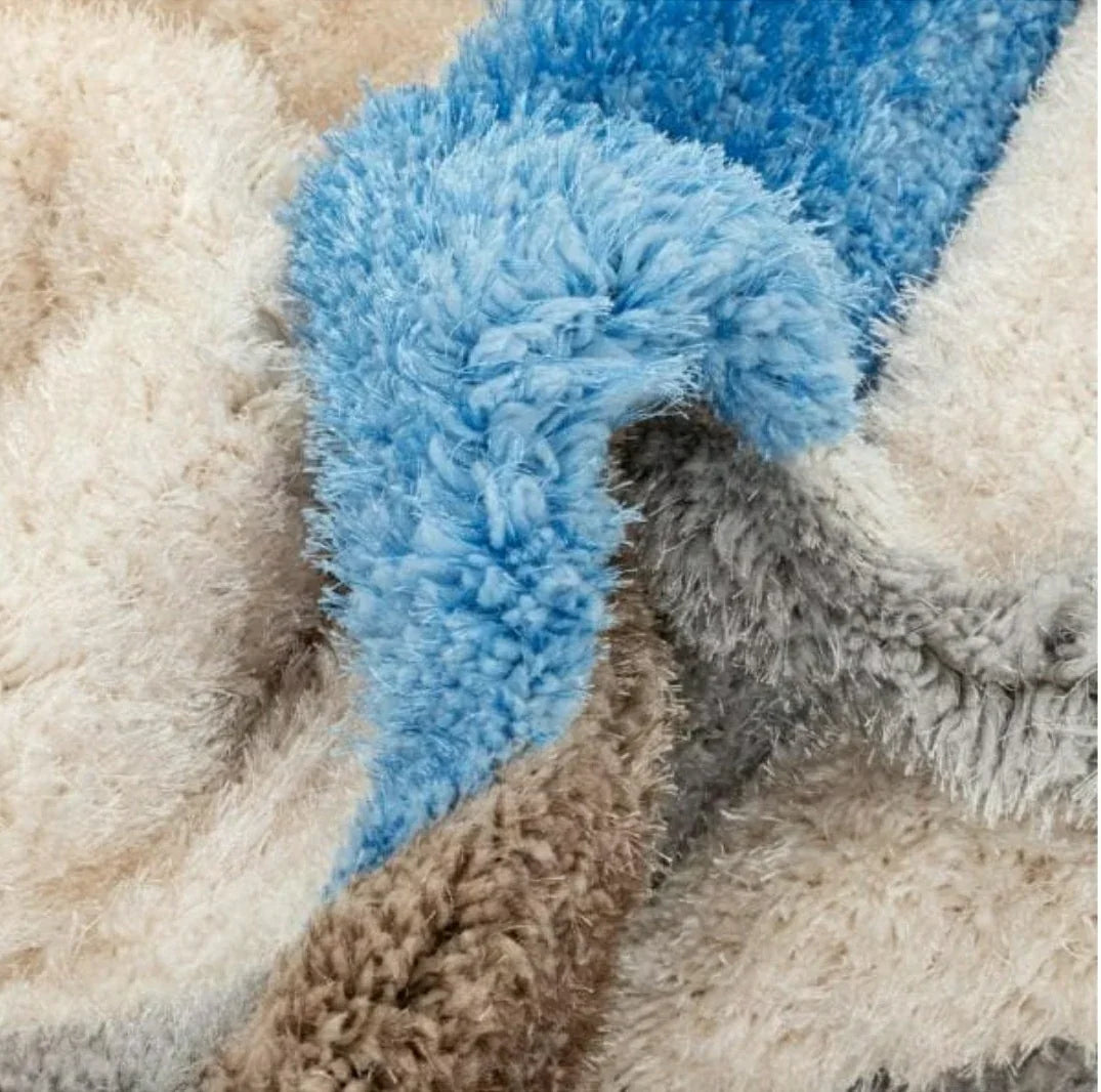 Close-up of a multicolor shaggy carpet rug with blue, beige, and grey fibers from Bhadohi Carpets House