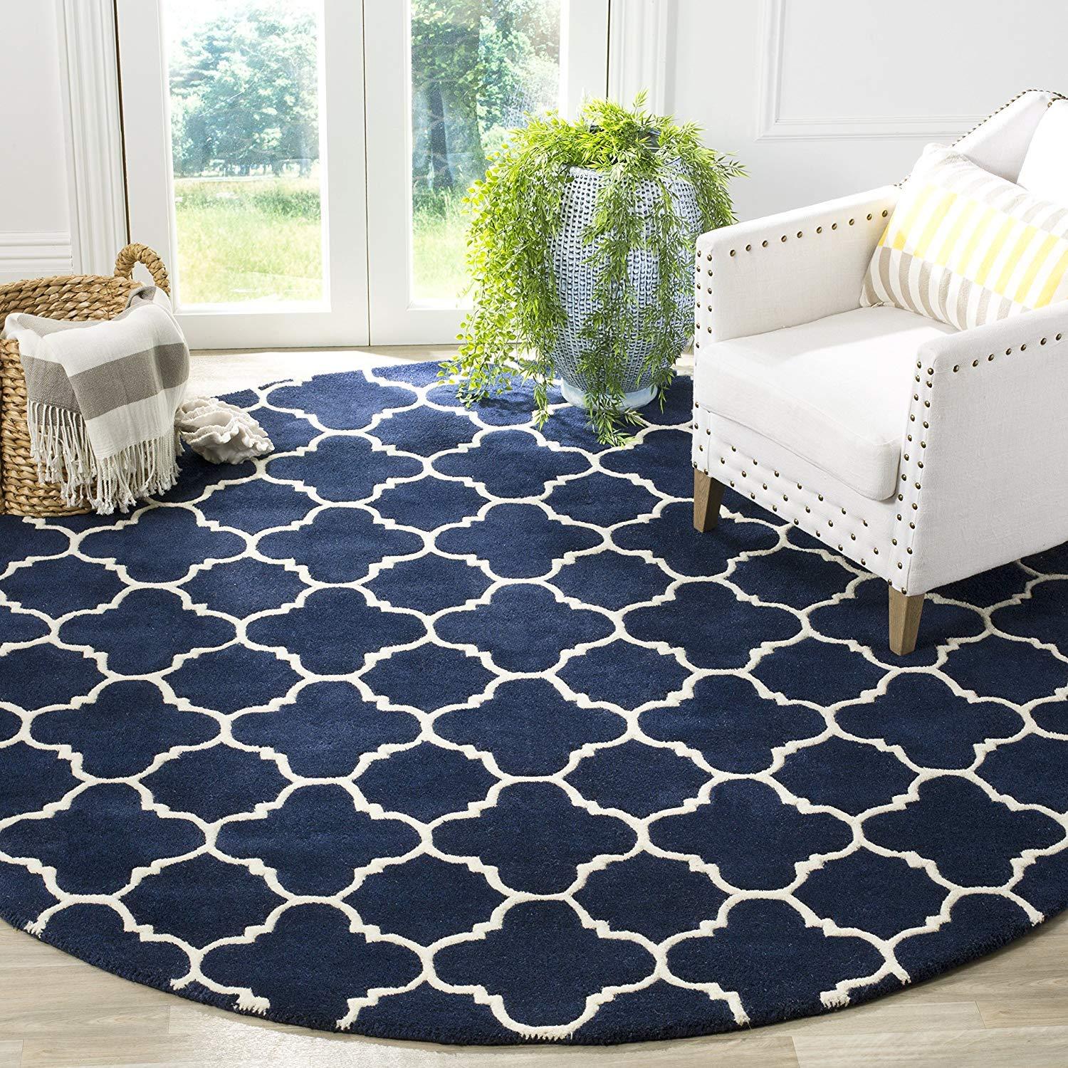 Navy blue round wool carpet with white geometric pattern in a modern living room