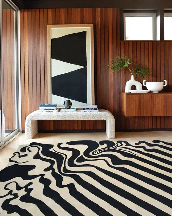 Modern living room with a black and cream abstract Bhadohi carpet, wood panel walls, art.