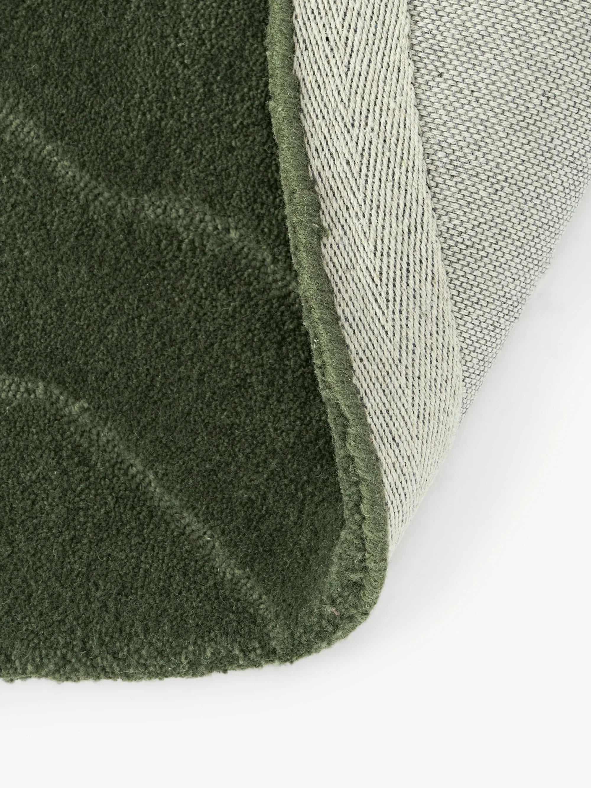 Close-up of a green wool carpet rug corner from Bhadohi Carpets House