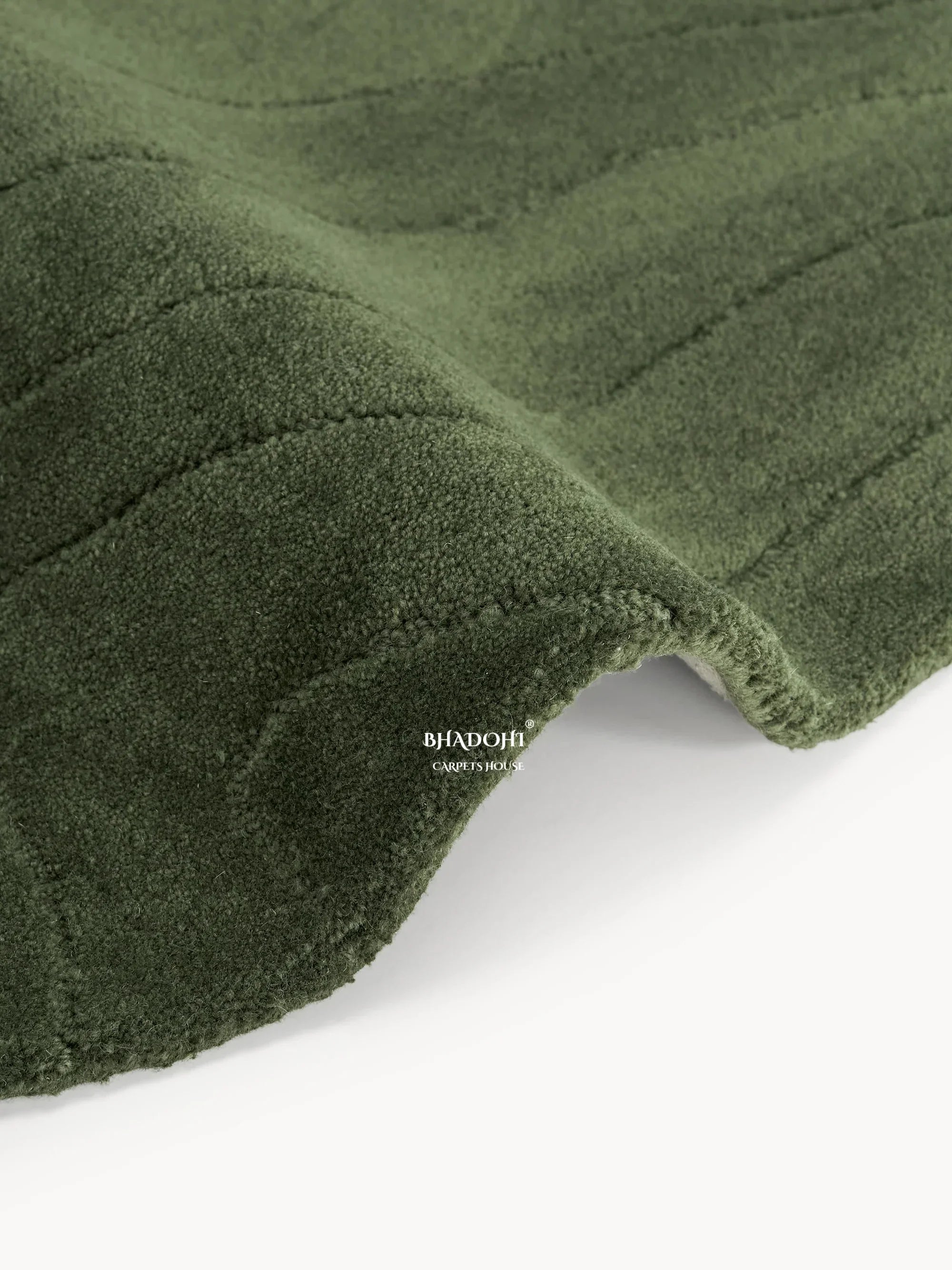 Close-up of a green wool carpet rug from Bhadohi Carpets House with textured surface