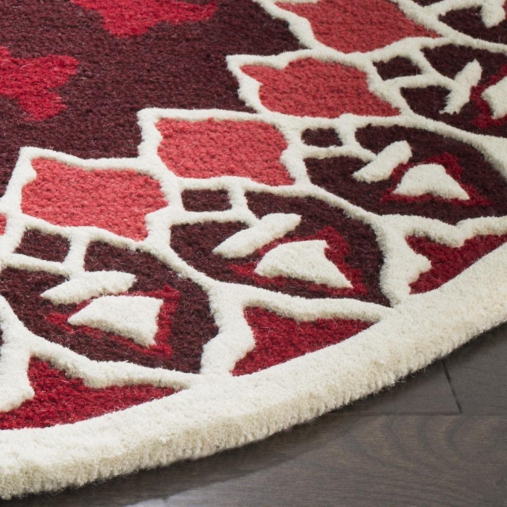 Red arc round wool carpet rug with floral pattern by Bhadohi Carpets House on wooden floor