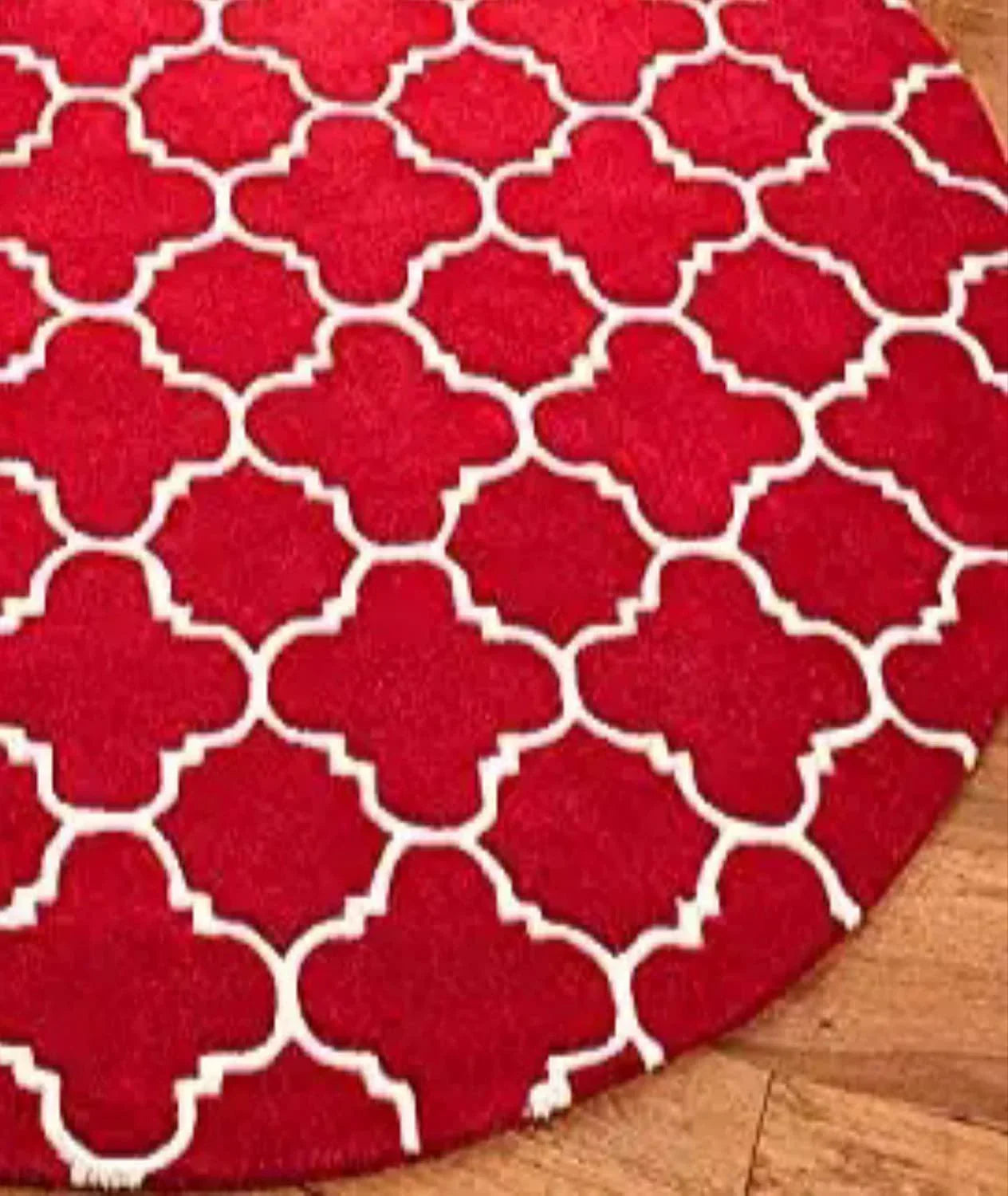 Red round wool carpet rug with white geometric pattern on wooden floor, Bhadohi Carpets House