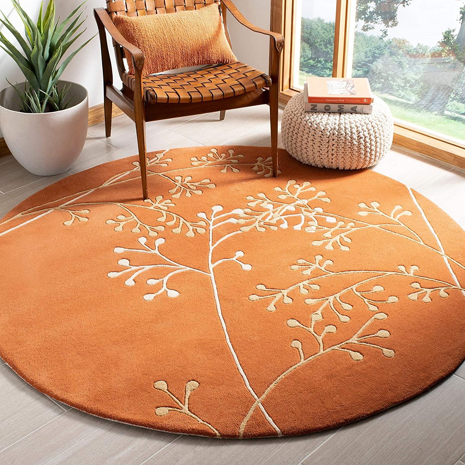 Rust berry round wool carpet rug with botanical design in a modern living room by Bhadohi Carpets House