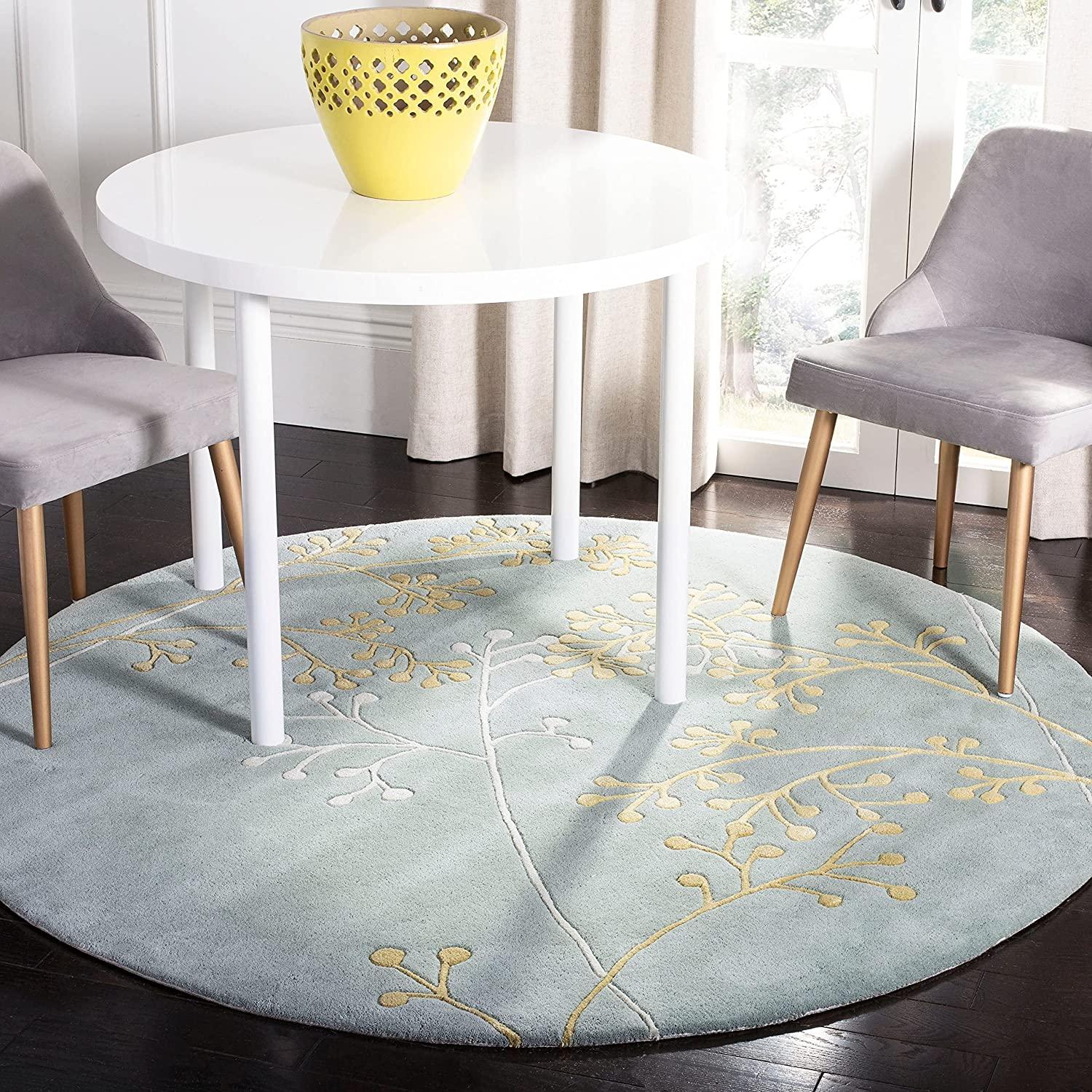 Sky blue round wool carpet with yellow floral pattern under table, Bhadohi Carpets House rug