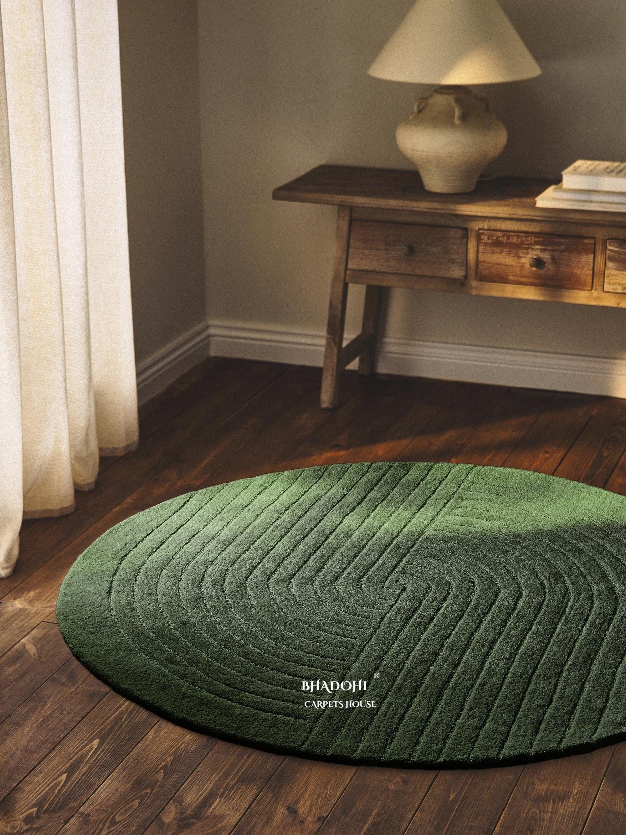 Modern green round wool rug by Bhadohi Carpets House on wooden floor in cozy home corner.