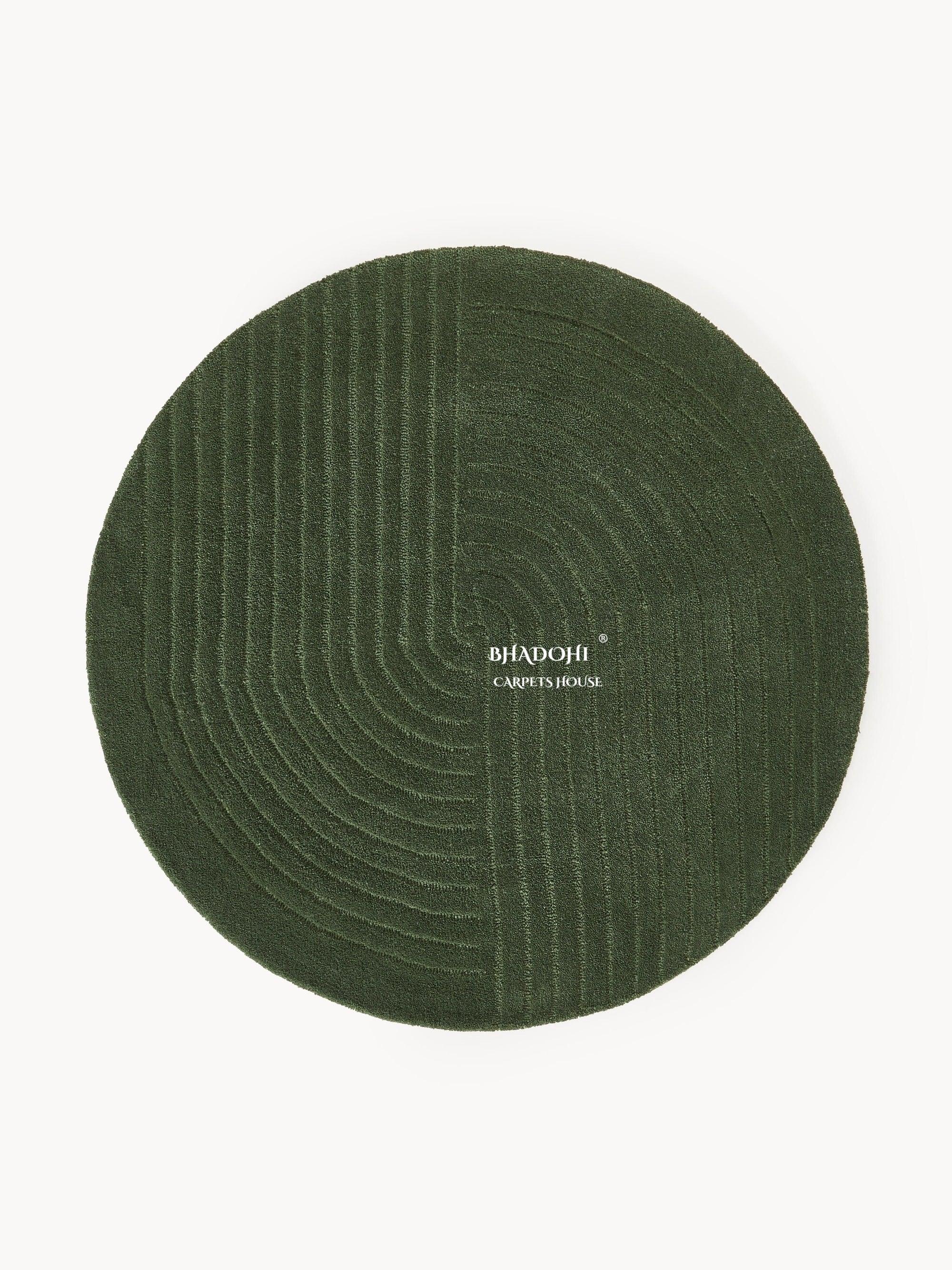Round green wool carpet rug with geometric lines, Bhadohi Carpets House logo, modern design