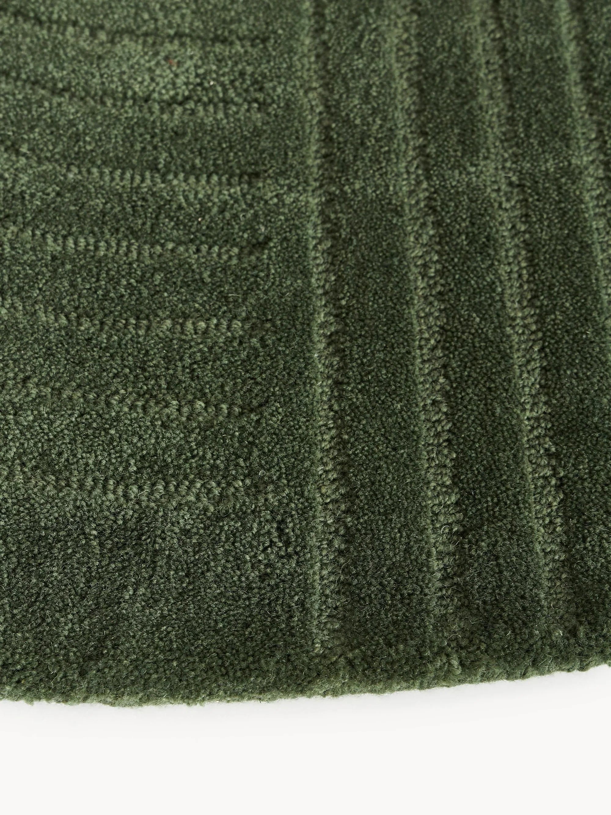Green wool round carpet rug with textured stripes from Bhadohi Carpets House
