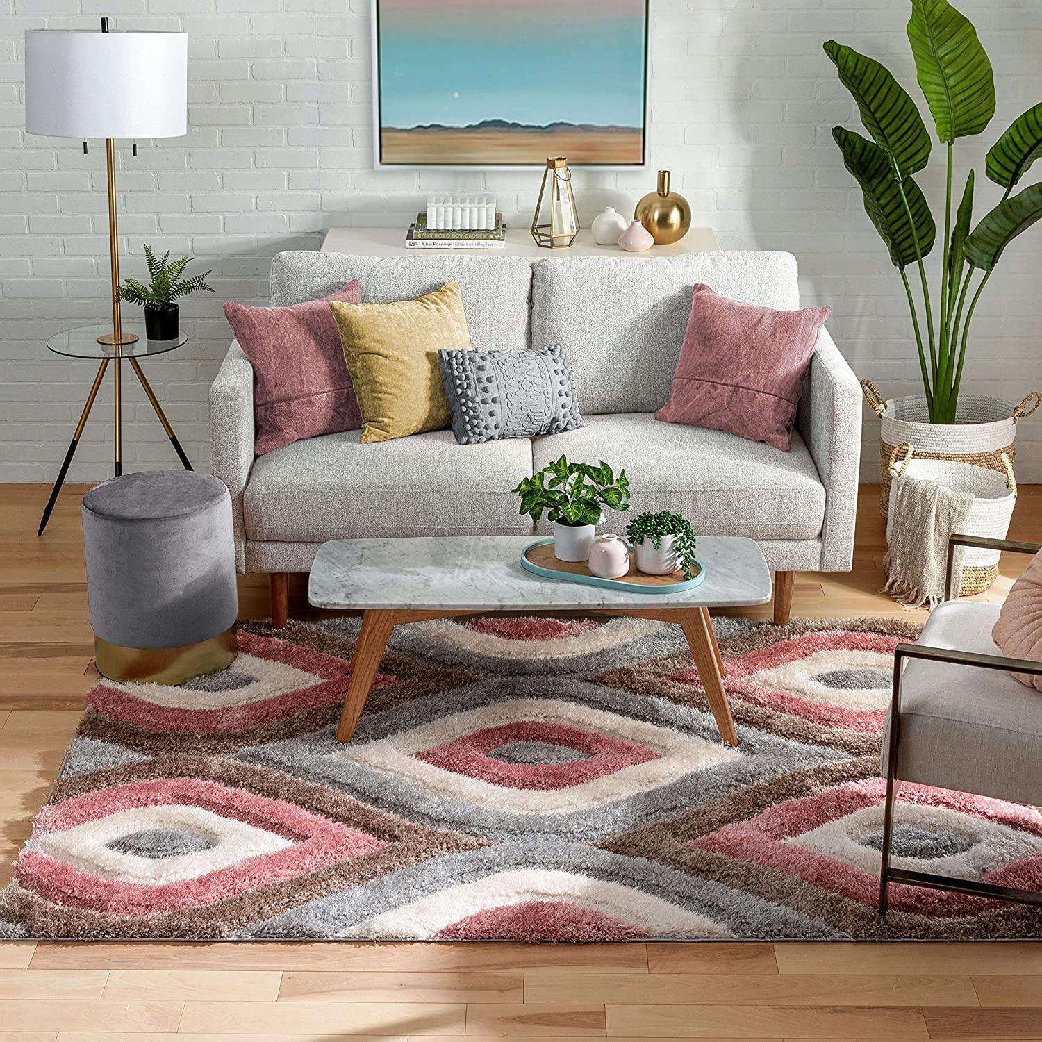 Modern living room with a geometric shaggy carpet rug, grey sofa, pastel cushions, and plants.