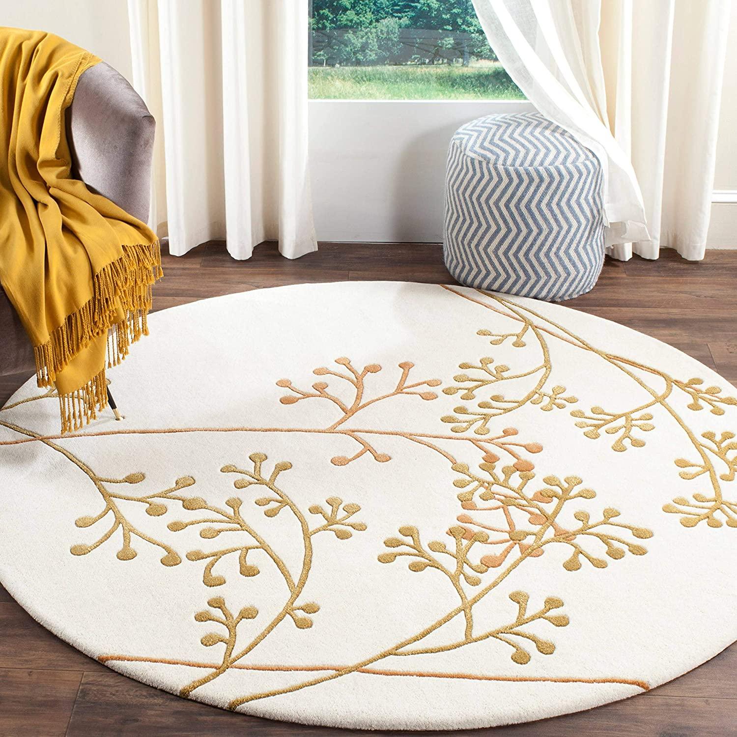 White and gold round wool carpet with berry pattern in a modern living room, Bhadohi Carpets House