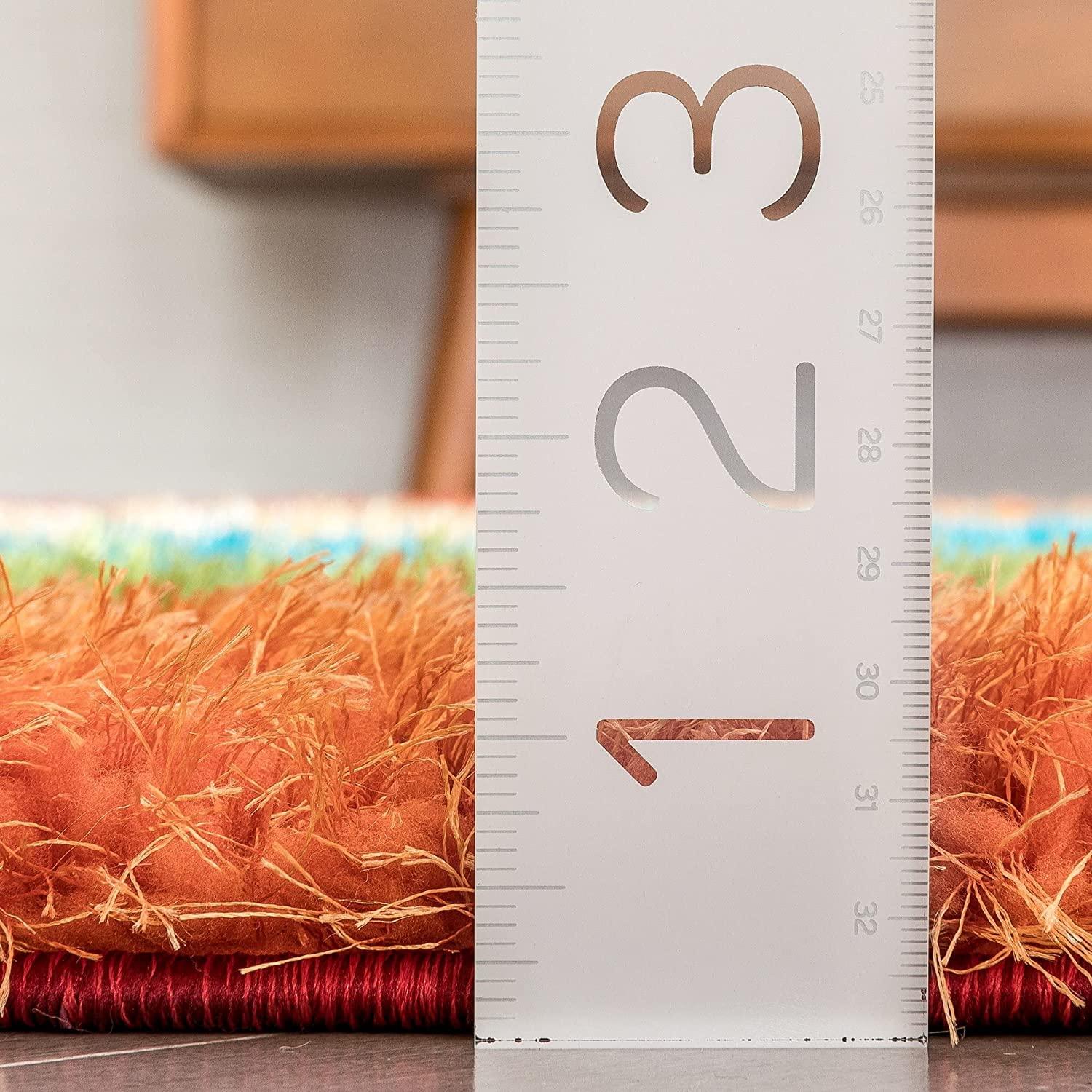 Close-up of orange shaggy carpet rug with ruler measuring pile height, Bhadohi Carpets House